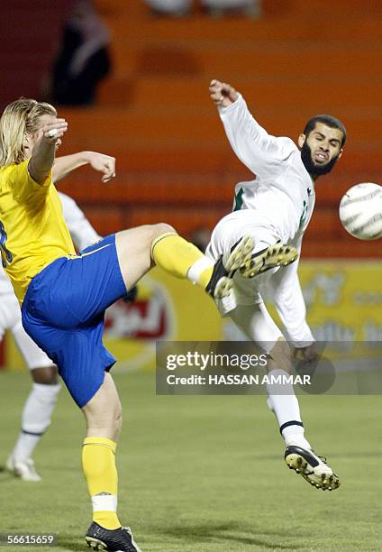 Saudi player Abdulaziz Khathran vies with Sweden player Fredrik Bergiund during an international friendly football match in Riyadh 18 January 2006....