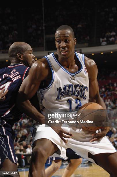 Dwight Howard of the Orlando Magic posts up against Marc Jackson of the New Jersey Nets during a game at TD Waterhouse Centre on December 21, 2005 in...