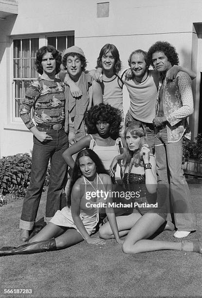 British rock group Streetwalkers with three female models at the band's signing to Phonogram Records, August 1975. Standing, left to right: guitarist...