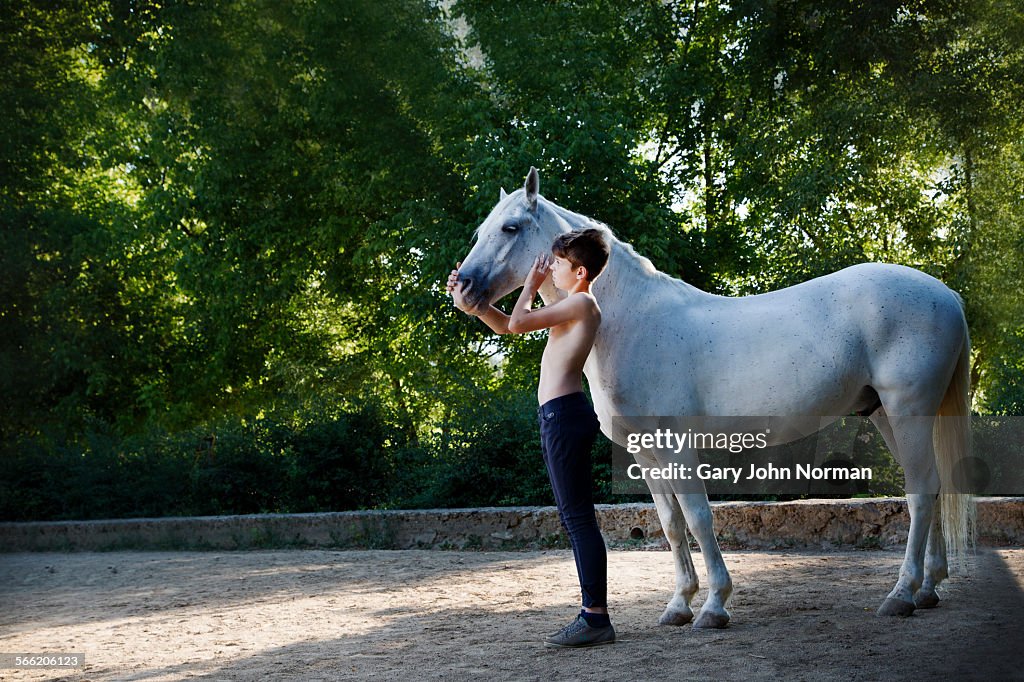 Boy and horse standing in yard