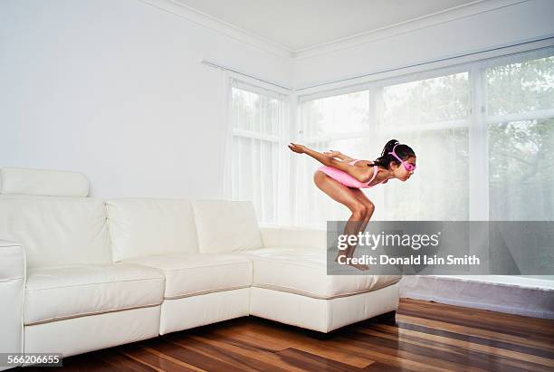 girl dives from sofa - girl diving fotografías e imágenes de stock