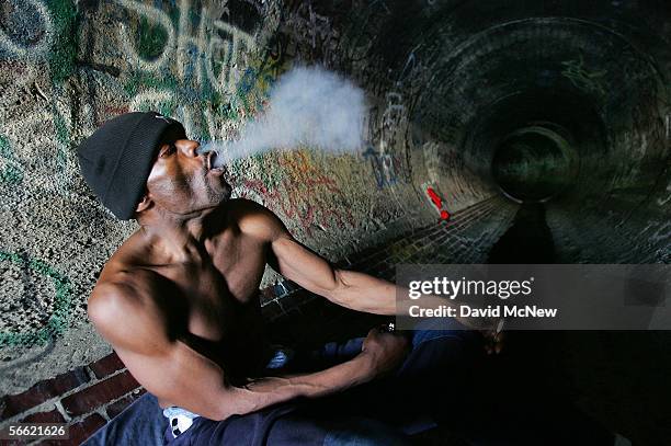 Donald Rayfield, known on the street as "Detroit", smokes crack cocaine in an underground storm drain on January 18, 2006 in Los Angeles, California....