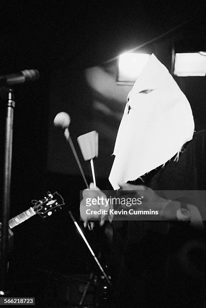 Singer Michael Riley performing, in a Ku Klux Klan hood, with English roots reggae band Steel Pulse at the Electric Circus, Manchester, 1st October...