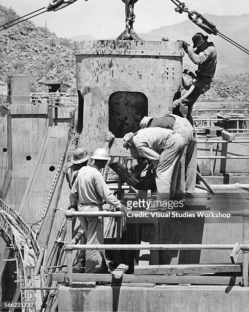 Construction workers pour the final bucket of concrete on the crest of the Bartlett Dam, which is 270 feet tall, and considered the highest of its...