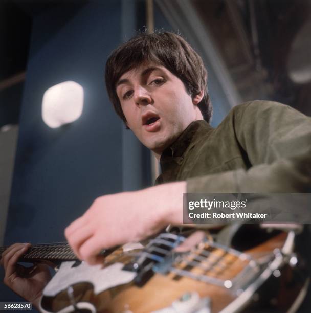 Paul McCartney of the Beatles singing and playing guitar during a recording session at Abbey Road.