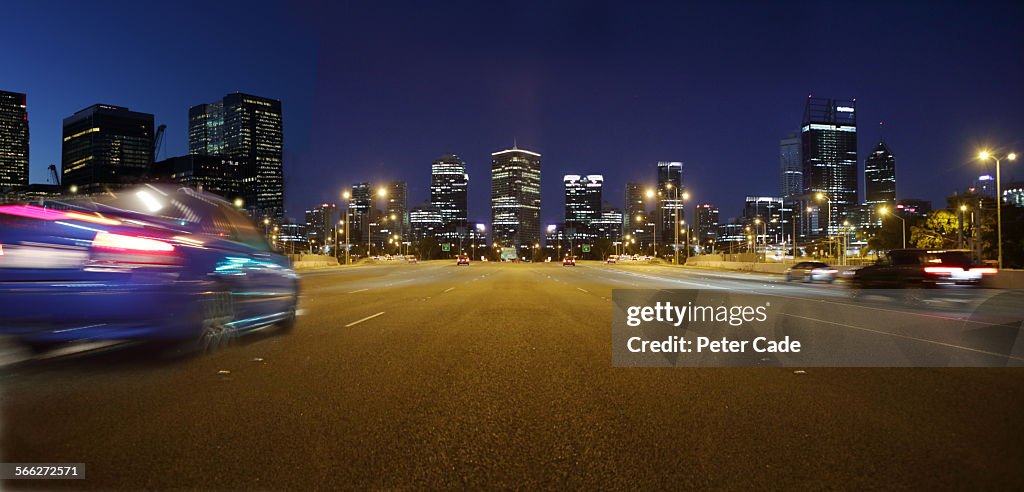 Cars at night on highway , city scape Perth .