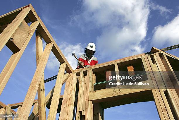 Construction worker hammers nails in the framing on a new home under construction January 19, 2006 in Dublin, California. The Commerce Department...