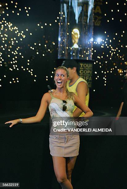 Una turista se hace tomar una fotografia delante de la Copa del Mundo Fifa, en exposicion en el Fuerte de Copacabana en Rio de Janeiro, Brasil, el 20...