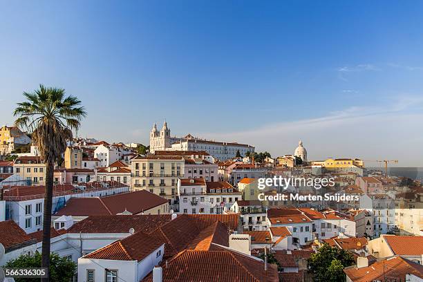 church above alfama rooftops at sunset - province de lisbonne photos et images de collection