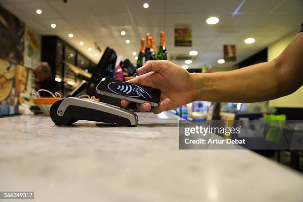 Man doing a contactless payment with smartphone application on a bakery.