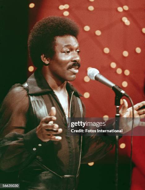 American r&b singer Wilson Pickett performs on stage, dressed in a leather vest over a transparent shirt, 1970s.