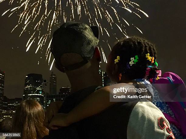 People watching the Macy's 4th of July New York City Fireworks Spectacular display over the Manhattan skyline from Pier 2 at Brooklyn Bridge Park -...