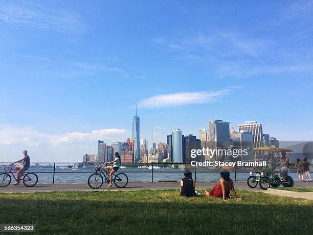 People enjoying a Summer day on Governors Island looking out at the Manhattan skyline.