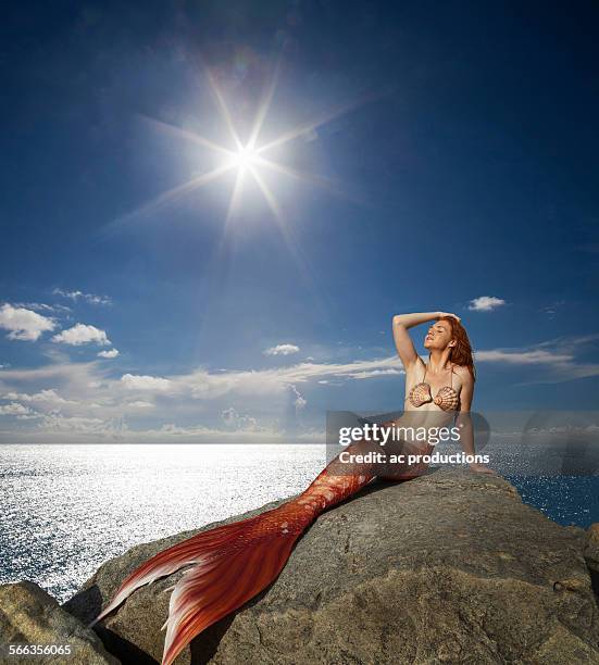 caucasian mermaid laying on rock near ocean - mermaid stock pictures, royalty-free photos & images