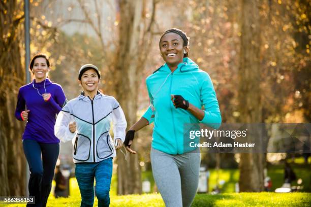 women running in park - mixed race woman stockfoto's en -beelden