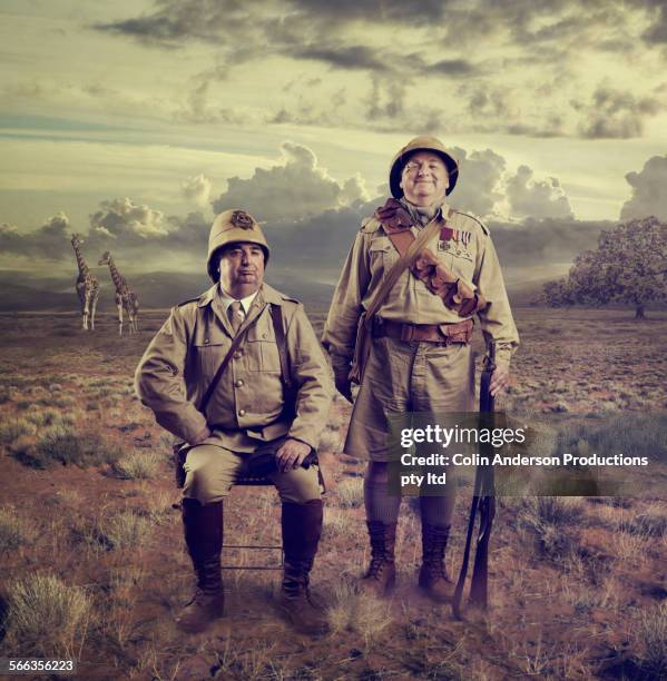 hunters posing in savanna landscape - safari animals stock photos et images de collection