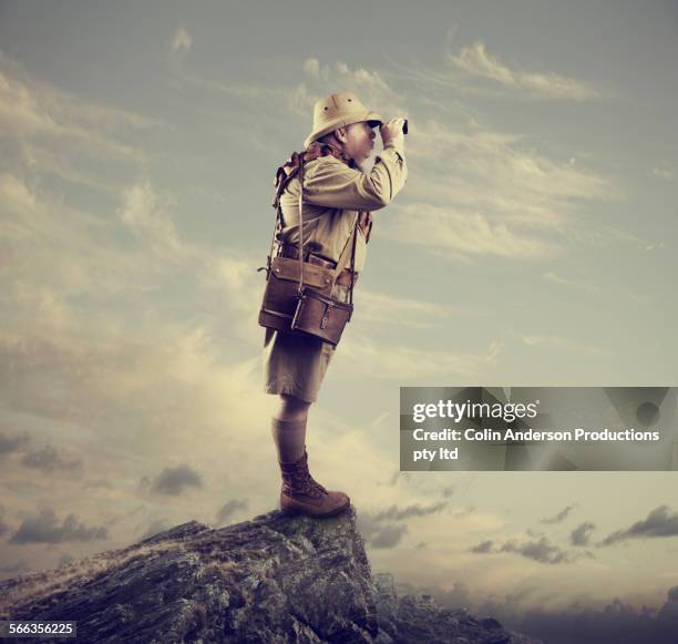 caucasian hunter using binoculars on mountaintop - mountain guide stock pictures, royalty-free photos & images