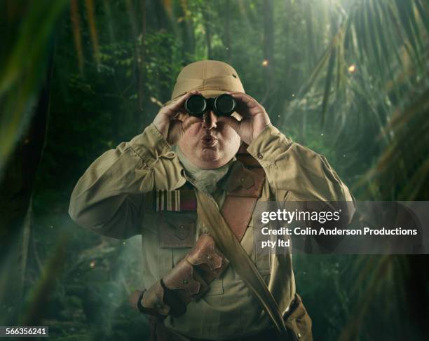 caucasian hunter peering through binoculars in jungle - search history stock pictures, royalty-free photos & images