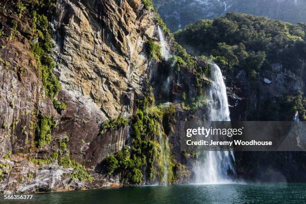 waterfall over sheer cliffs to remote river, te anau, southland, new zealand - te anau stock pictures, royalty-free photos & images