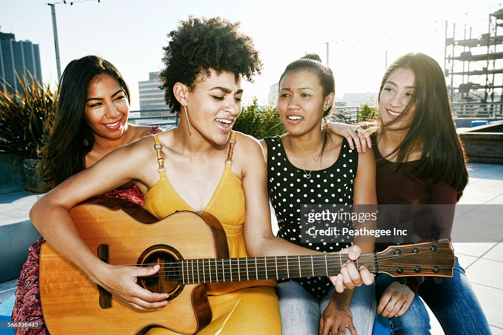 Women playing music and singing on urban rooftop