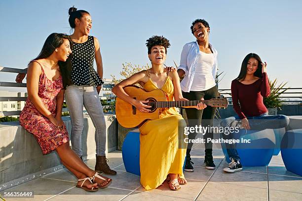 women playing music and singing on urban rooftop - young woman standing against clear sky stock pictures, royalty-free photos & images