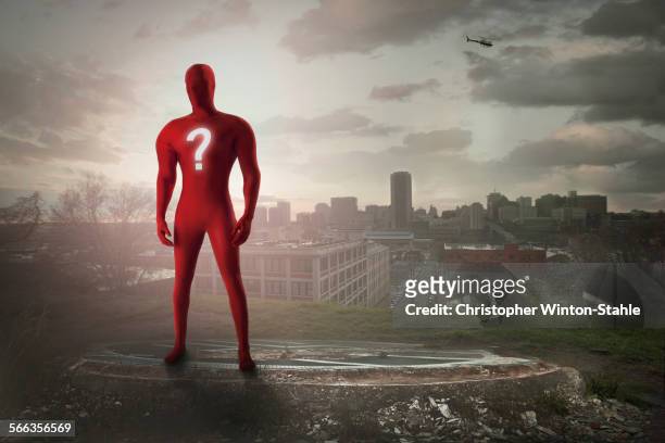superhero with question mark costume overlooking cityscape - manquestionmark stock pictures, royalty-free photos & images