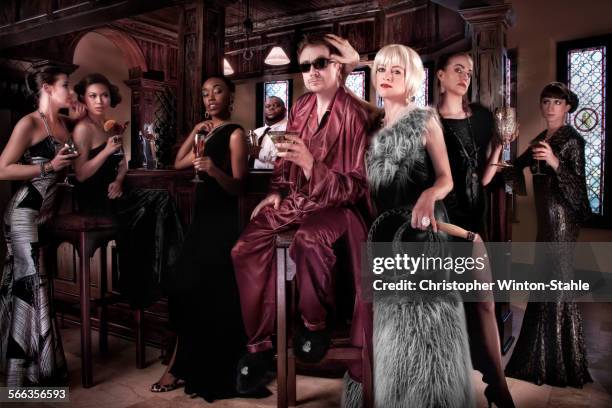 models surrounding powerful man in pajamas at party - luxury pyjamas stock pictures, royalty-free photos & images