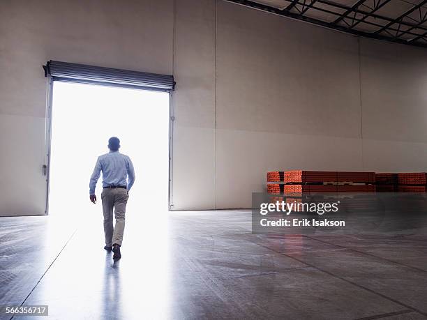 caucasian businessman walking in warehouse - leave fotografías e imágenes de stock