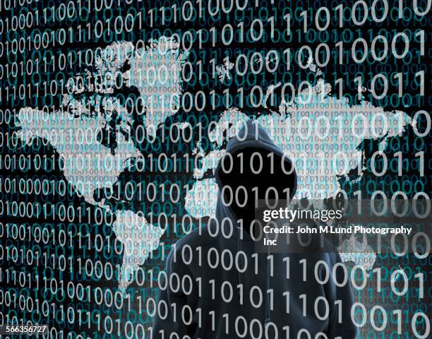 hacker wearing hoody standing behind binary code - unrecognizable person photos stock illustrations