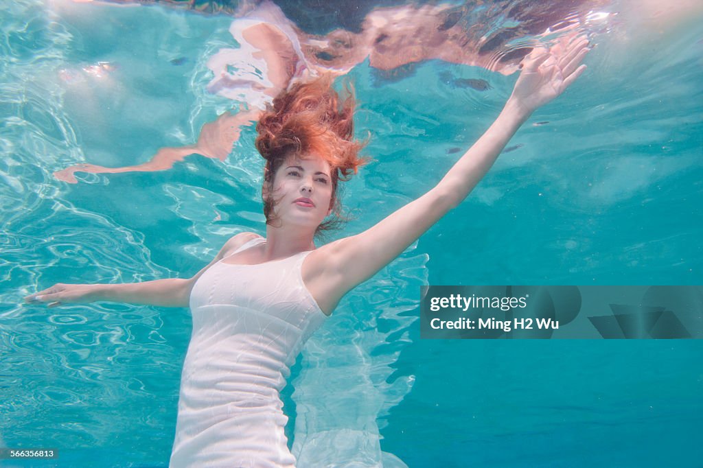Underwater View Of Mixed Race Woman In Dress Swimming In Pool High-Res ...