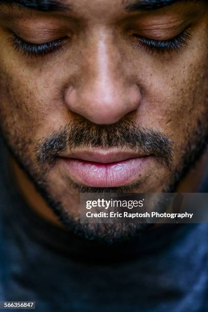 close up of face mixed race man looking down - face down stock-fotos und bilder