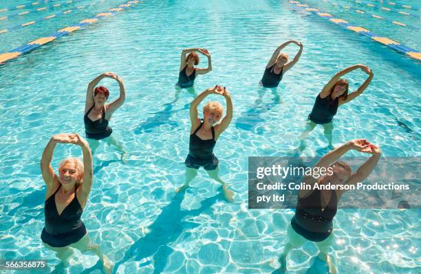 older caucasian women taking fitness class in swimming pool - dance fitness stock-fotos und bilder