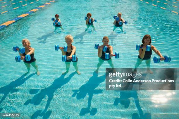 Older Caucasian women taking fitness class in swimming pool