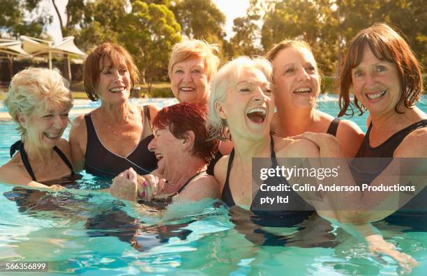 older caucasian women talking in swimming pool - buitenbad stockfoto's en -beelden