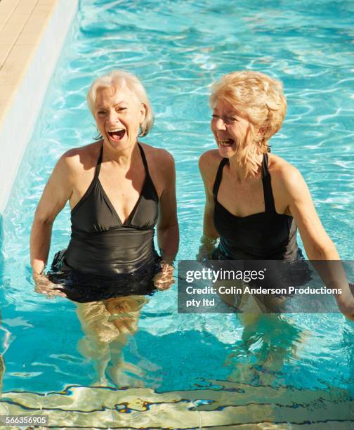 older caucasian women talking in swimming pool - woman swimsuit happy normal stock pictures, royalty-free photos & images