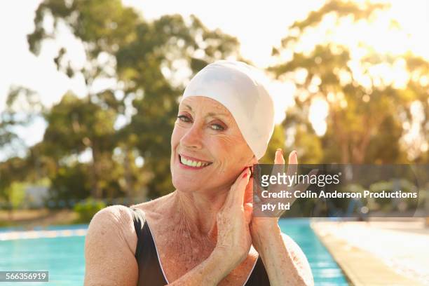 older caucasian woman wearing swimming cap in pool - woman swimsuit happy normal stock pictures, royalty-free photos & images