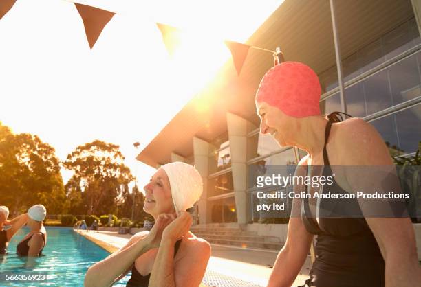 older caucasian women wearing swimming caps in pool - woman swimsuit happy normal stock pictures, royalty-free photos & images