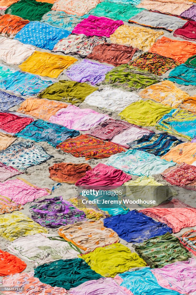 High angle view of colorful saris drying on flat ground