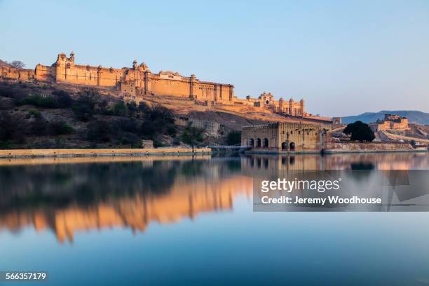 amber fort reflecting in still river under blue sky, jaipur, rajashan, india - amber fort stockfoto's en -beelden