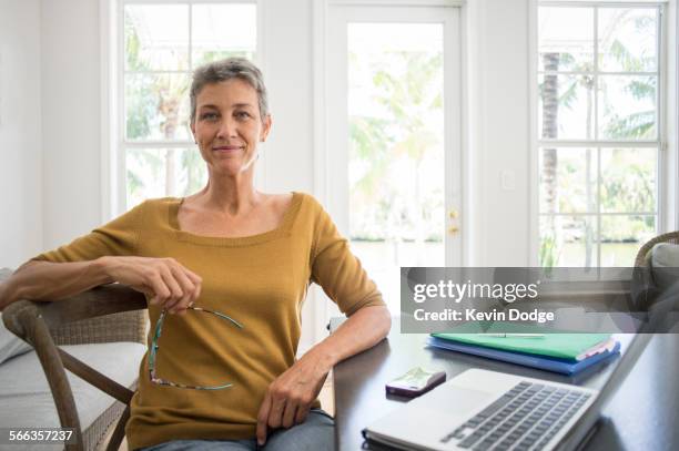 woman using laptop in living room - 50 54 jahre stock-fotos und bilder