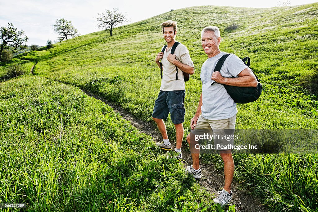 Caucasian father and son walking on dirt path