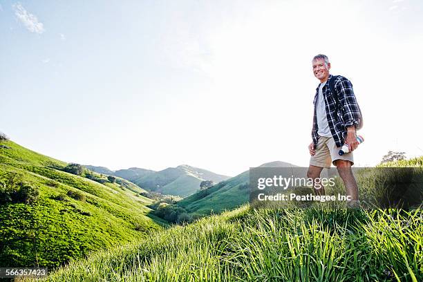 older caucasian man smiling on grassy hillside - low angle view grass stock pictures, royalty-free photos & images