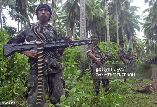 Armed followers of jailed Muslim rebel chieftain Nur Misuari line the road to their camp in the southern Philippine island of Jolo where military...