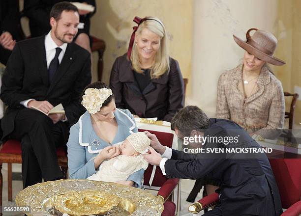 Danish Crown Prince Frederik adjusts the cap of his son, prince Christian Valdemar Henri John held by his mother Australian-born Princess Mary, after...