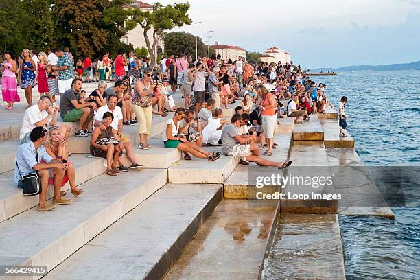 People on the steps of the Sea Organ in Zadar on the Adriatic coast of Croatia.