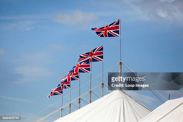 Series of Union Jack flags on top of a marquee at Goodwood revival.