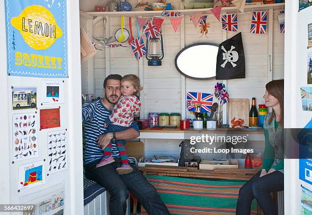 Young family in their beach hut at Cromer on the Norfolk coast.