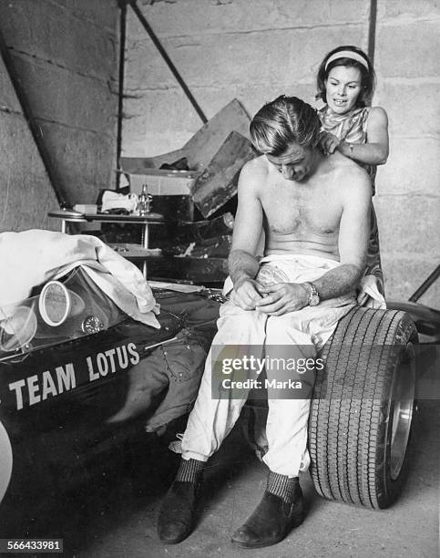 Graham Hill Sits On The Wheel Of His Ford Lotus Having A Massage, 1967.