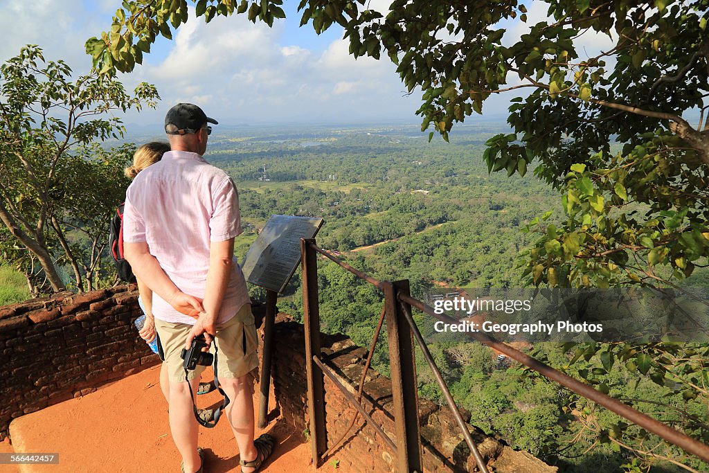 Two people looking down at the water gardens from rock palace fort, Sigiriya, Central Province, Sri Lanka