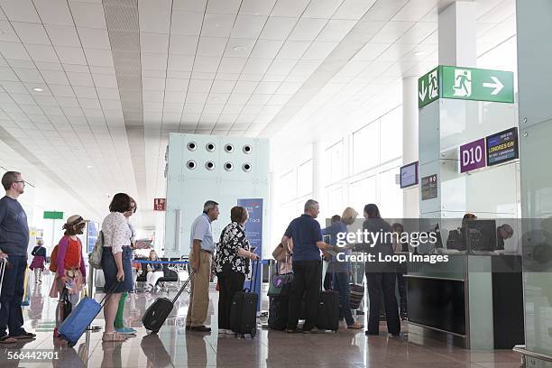 Passengers queuing to board at airport departure gate.